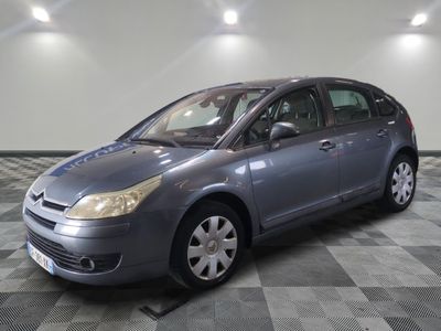 the grey car is parked on the checkered floor in the garage