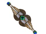 un gros plan d'une broche ornée de perles de verre vertes et bleues