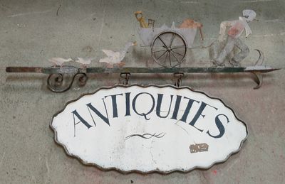 une enseigne indiquant « antiquités » sur la façade d'un immeuble