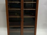an antique wooden bookcase with glass doors and shelves