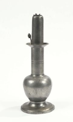 an old silver vase sitting on top of a white surface