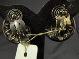a pair of earrings with a tag attached to them