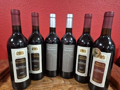 six bottles of red wine are lined up on a barrel