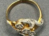a gold ring with a bird on it on a table
