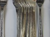 a lot of forks and spoons that are on the table