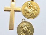 three gold religious pendants with a cross on a white background