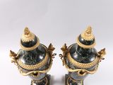 pair of black and gold vases with handles on a white background