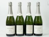 quatre bouteilles de champagne sont alignées sur une surface blanche
