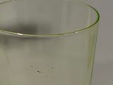 a green glass with a yellow rim sitting on a table