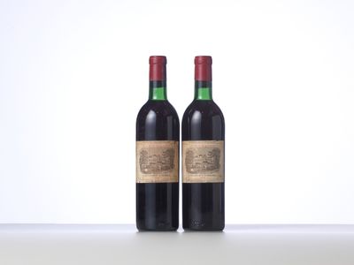 two bottles of red wine sitting on top of a table