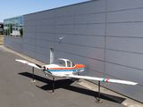un petit avion garé devant un immeuble