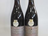 two bottles of wine sitting on top of a table next to each other