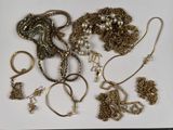 de nombreux bijoux en or disposés sur une assiette blanche