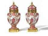pair of pink and white vases with gold trimmings on them