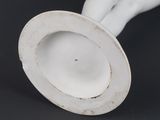 a white vase with a white base on a black background