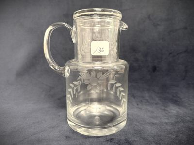 a glass pitcher with a handle and a label on it