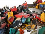 a pile of toy cars and trucks on a white surface