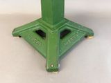 a green table top with a metal base on a white surface