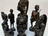 several african figurines sitting on top of each other on a white surface
