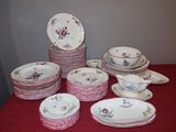 a lot of plates and bowls on a red table