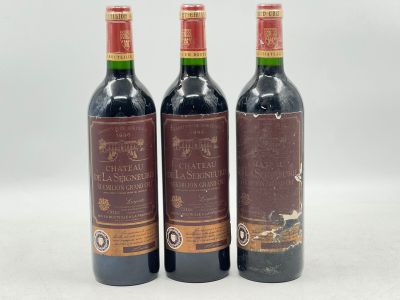 trois bouteilles de vin posées sur une table l'une à côté de l'autre