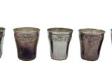 six different shot glasses lined up in a row on a white background