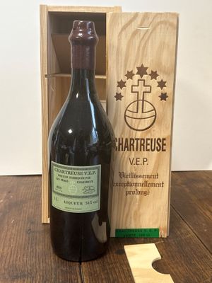 une bouteille de vin posée sur une table à côté d'une caisse en bois