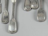 several silver spoons and spoon spoons are lined up on a table
