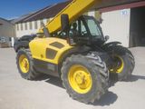 a picture of a yellow and black tractor parked in front of a building