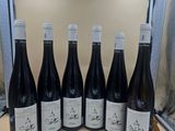 six bouteilles de vin sont alignées sur un comptoir