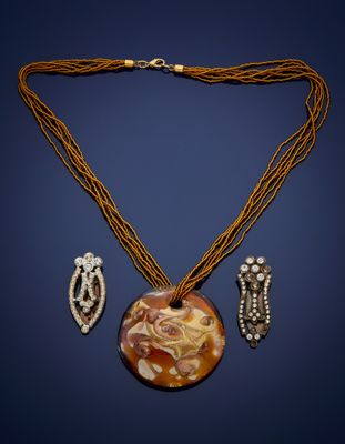 un gros plan d'un collier et de boucles d'oreilles sur fond bleu