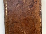 un vieux portefeuille en cuir marron sur lequel est encore accrochée une étiquette de prix