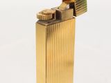 gold lighter on a white surface with a white background