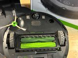 a black robot with a green brush in front of a box