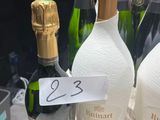 plusieurs bouteilles de champagne posées sur une table, avec une étiquette indiquant le prix