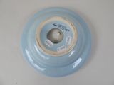 a blue bowl with a hole in it on a white table