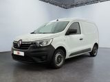 La camionnette blanche est garée dans une grande pièce.