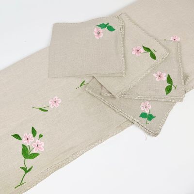 three placemats with pink flowers on them on a white table