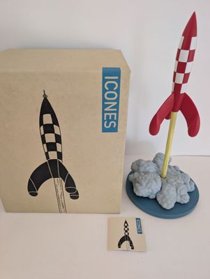 a toy rocket sitting next to a cardboard box on a table