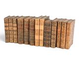 several old books are stacked on top of each other on a white surface