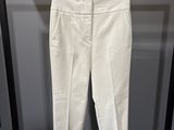 un pantalon blanc suspendu à un portant dans une pièce