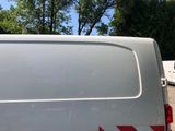 a white van parked in a parking lot with trees in the background