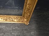 a picture of a gold framed mirror on the floor