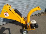 a small yellow machine that is parked in front of a garage