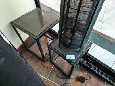une table avec un plateau en verre et un piètement en métal surmonté d'un plateau en verre