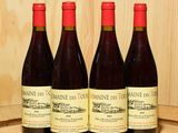 trois bouteilles de vin sont posées sur un tonneau en bois devant un mur en bois