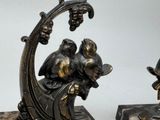 two figurines of birds sitting on top of a tree