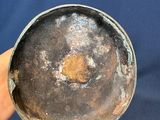 a person holding a metal bowl on a blue surface