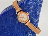 une image représentant une montre-bracelet posée sur un vase bleu