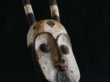 un gros plan d'un masque en bois muni de cornes sur fond noir